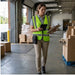 Warehouse employee wearing an AgozTech rugged CipherLab handheld case with belt clip while checking a tablet and clipboard during shift-based logistics work.
