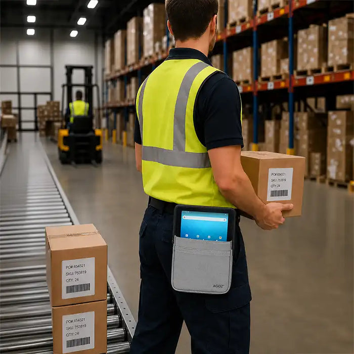 Warehouse worker carrying a Unitech RT112 tablet in a gray Agoz waist belt case while handling inventory