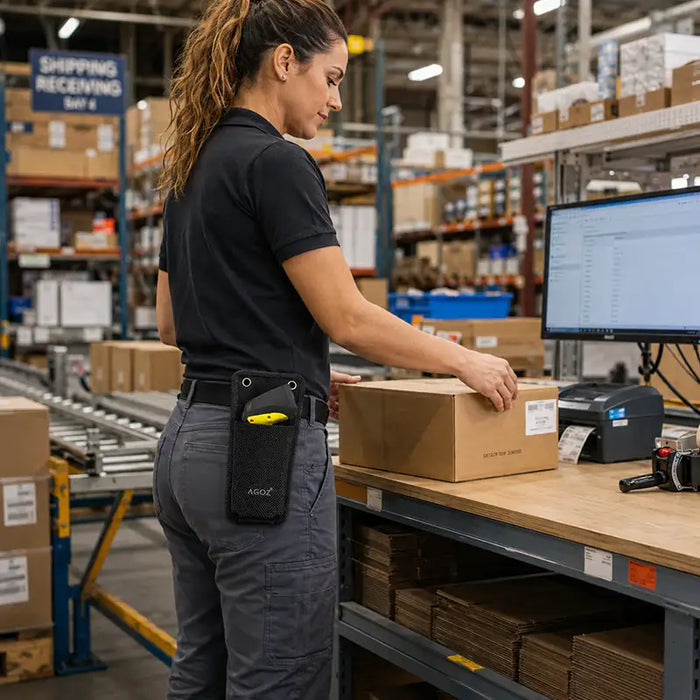 Worker wearing an Agoz wireless scanner mountable case with a Unitech scanner while packing boxes at a shipping and receiving workstation.