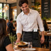 Restaurant server wearing Clover Flex POS holster with waist belt for tableside payment access