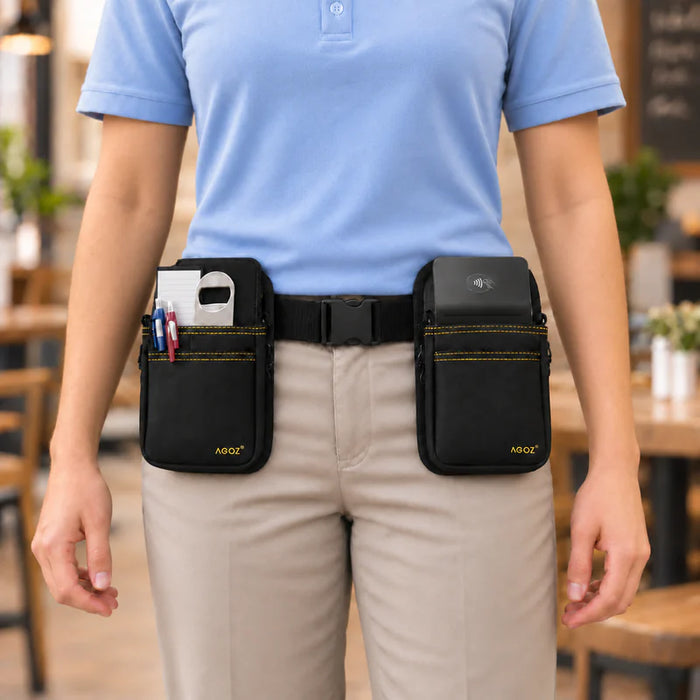 A person wearing a light blue polo shirt and khaki pants models a black waist bag set with two front POS pouches. The left pouch holds pens, and the right pouch holds a small black device.