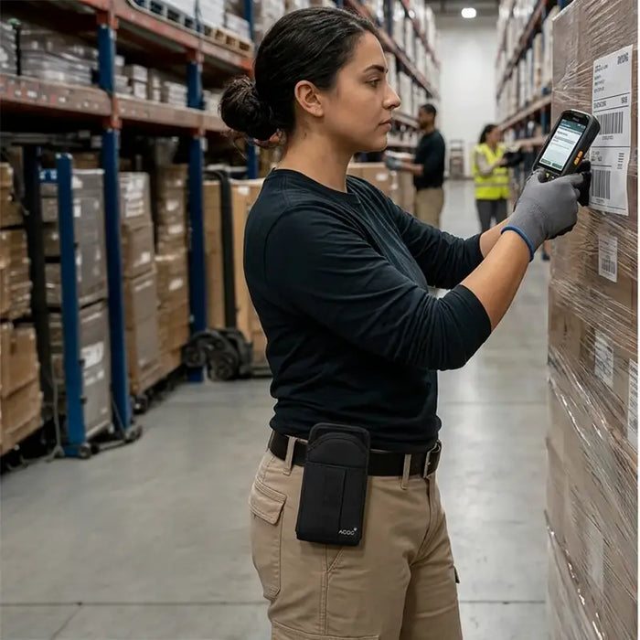 Warehouse worker wearing an AgozTech scanner case while using a CipherLab mobile computer to scan pallet labels during warehouse inventory operations.