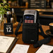 Agoz crossbody carrying case with a SpotOn payment terminal displayed on a restaurant table beside menus, an order slip, and table signage.