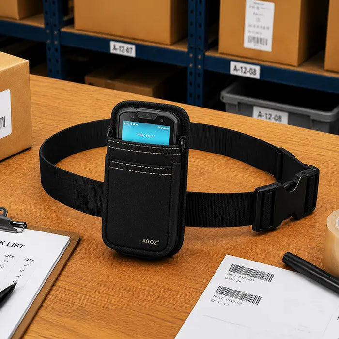 Black Unitech waist belt pouch displayed on a warehouse pick station with a compact scanner, pick list, barcode labels, and packing materials.