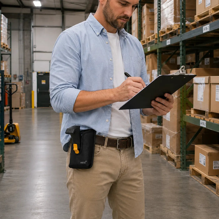Warehouse employee writing on a clipboard while wearing a black AGOZ belt holster holding a Cipherlab handheld scanner in a bright storage aisle.