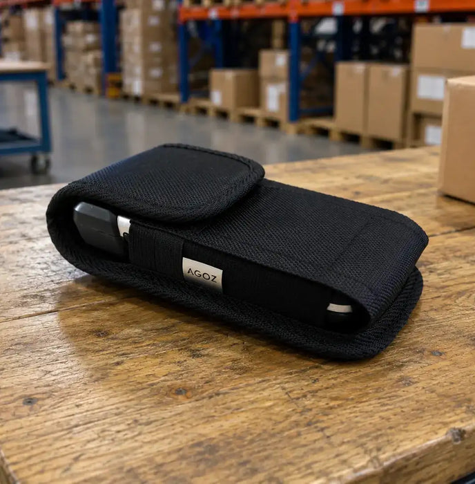 Black AGOZ Cipherlab scanner case holding a handheld device on a wooden warehouse worktable, with storage racks and boxes in the background.
