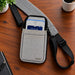 myPOS payment terminal secured in an Agoz gray canvas holster with padded adjustable crossbody sling on a wooden tabletop.